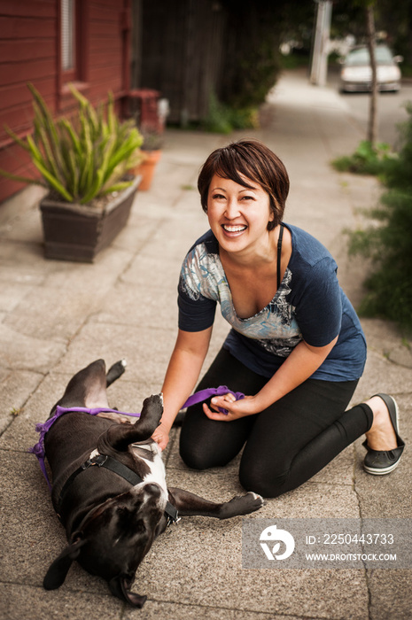 Portrait of young woman playing with dog