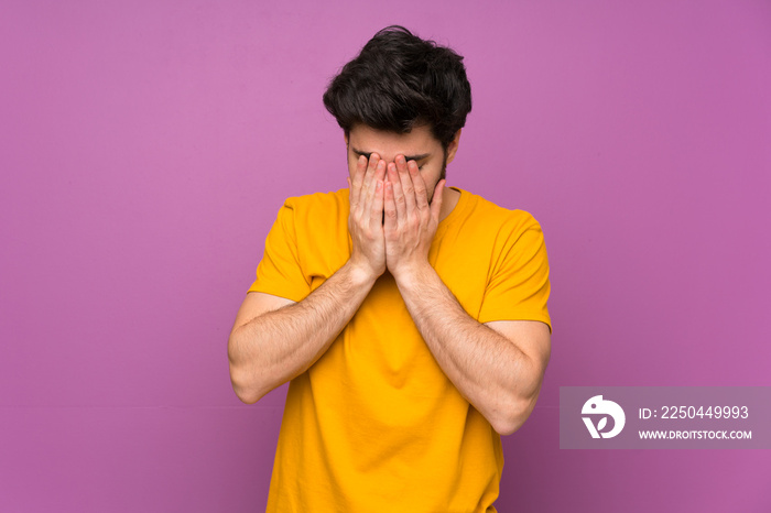 Handsome over isolated purple wall with tired and sick expression