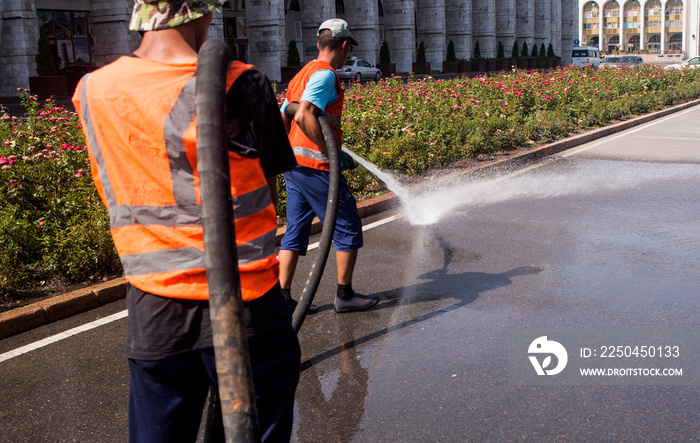 Employees of the municipality washes the street with water pressure from the car.