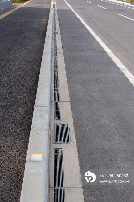 a curb sandwiched between the sidewalk and the driveway