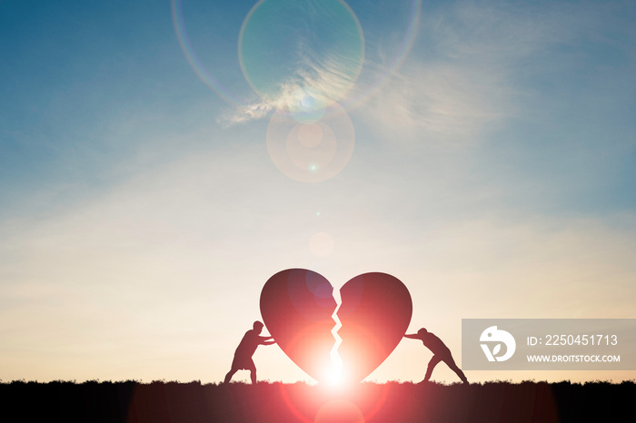 Two silhouette men pushing broken heart with sunlight and blue sky , Valentine s day concept.