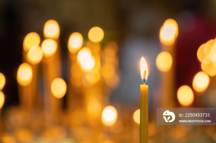 Candle light in christian church warm tone with dark black background