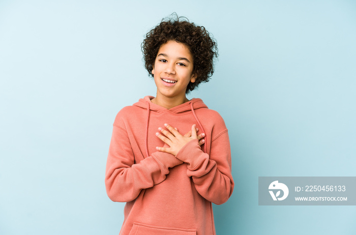 African american little boy isolated has friendly expression, pressing palm to chest. Love concept.