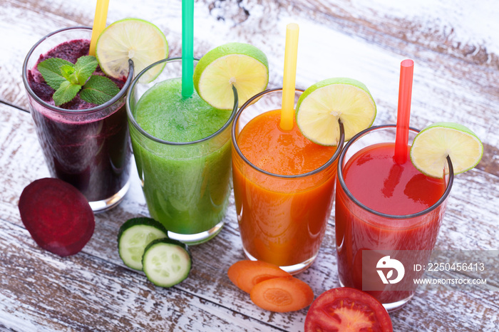 Vegetables, fresh juices mix fruit healthy drinks on wood table.