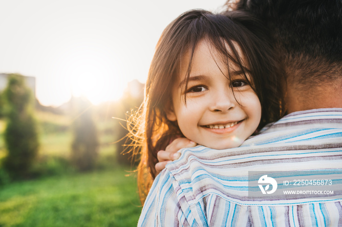 Closeup image of happy daughter embraces her dad feels joyful. Happy cute little girl playing with f