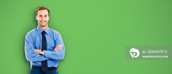 Portrait of happy smiling businessman, standing in crossed arm pose, over green color background. Co
