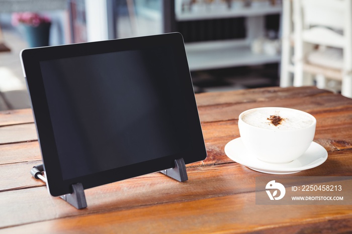 桌子上的咖啡杯和数字平板电脑