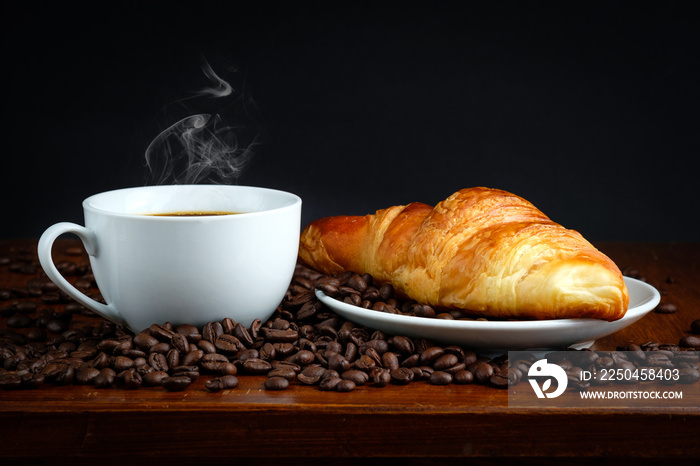 French breakfast: croissant bread and black coffee with coffee beans on table