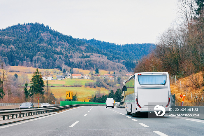 White touristic bus in road. Tour modern shuttle bus back on highway. Urban Transport with driver. E