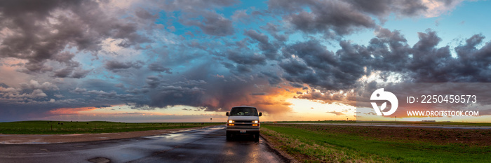 Stormy looking skies behind a camper van life car in Wyoming, United States during summer time with 