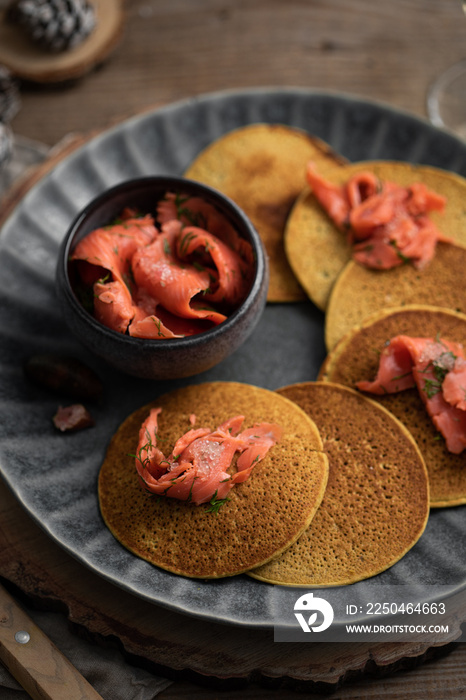 Pancakes salés fait maison avec saumon et citron caviar pour lapéritif de fêtes et verre de vin bla