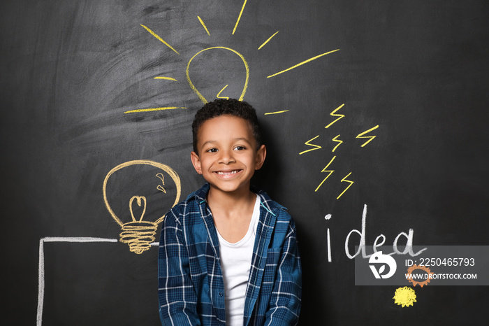 African-American boy near drawn light bulbs on dark wall