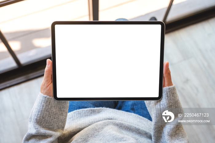 Top view mockup image of a woman holding black tablet pc with blank white screen
