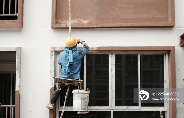 一名工人爬上大楼为新立面上色