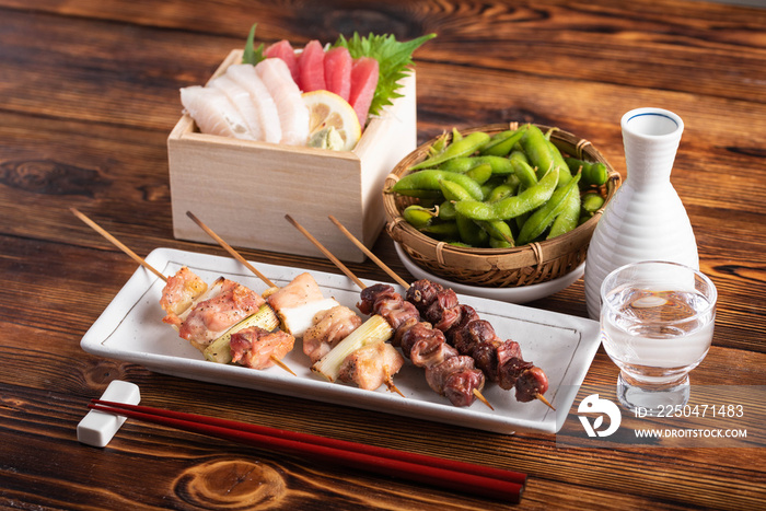 japanese popular izakaya food and sake, edamame, sashimi, yakitori