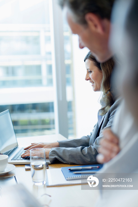 Businesswoman using laptop in conference room meeting