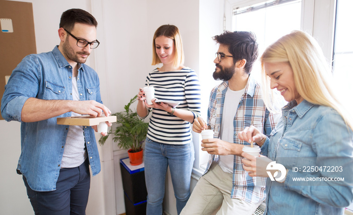 Group of young cheerful happy coworkers having a break together with coffee in the paper cup.