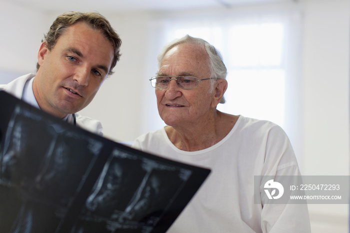 Male doctor showing x-rays to senior patient in hospital