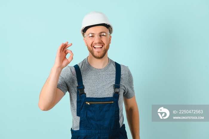 工匠或电工在孤立的蓝色背景上用手指显示ok标志