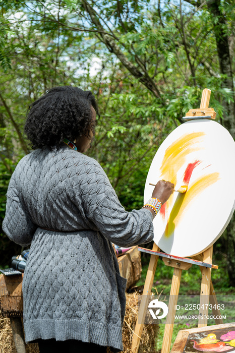 back portrait of a female painter at work