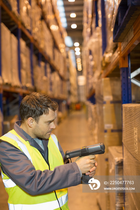 Male worker scanning boxes in distribution warehouse