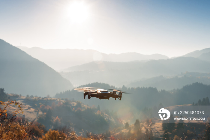 小型现代无人机在山上盘旋拍摄日出。