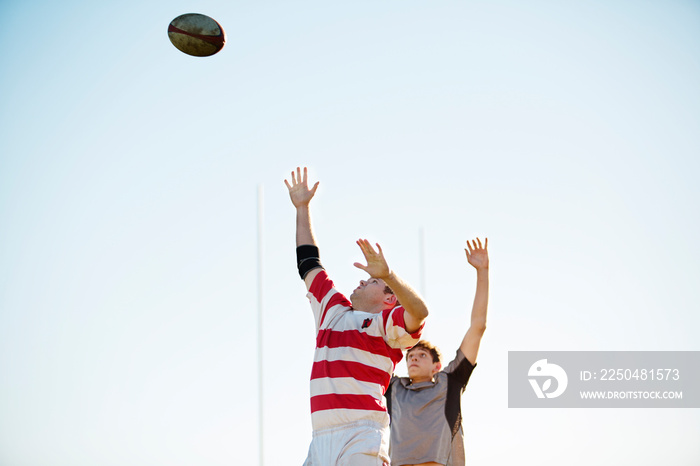 Two football players catching ball