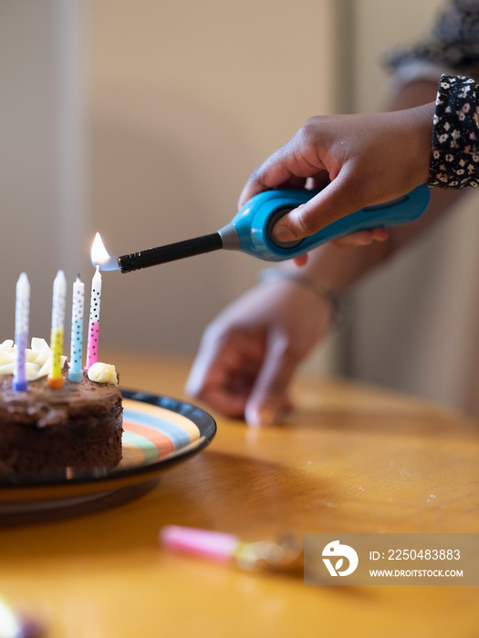 Girl lighting candles on birthday cake