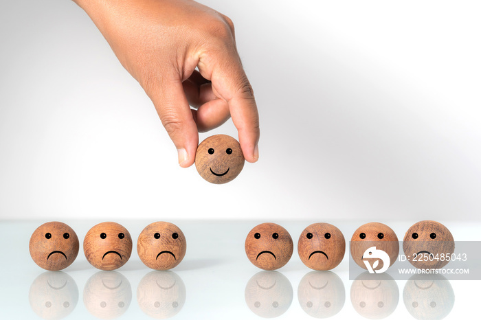 Hand putting on a smiling wooden ball, Concept of recruiting