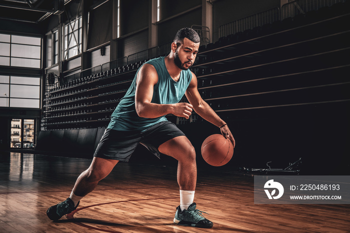 Full body portrait of Black professional basketball player in an action in basketball field.