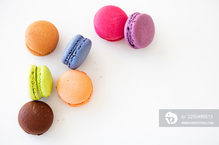 Colorful macarons on white background, close up view