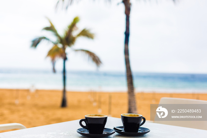 日落或日出海滩时，木桌上的咖啡杯特写