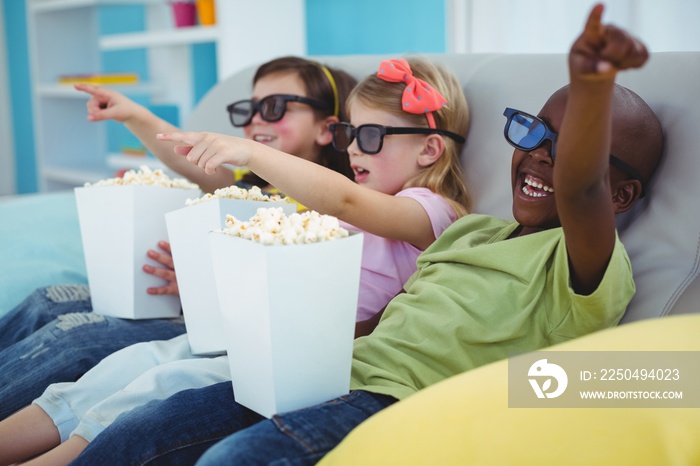 Happy kids sitting together watching a movie