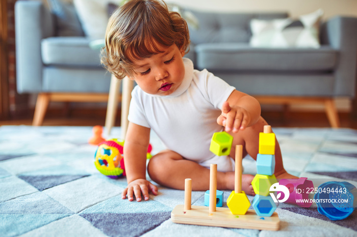 Beautiful toddler child girl playing with toys on the carpet