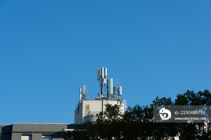 Antennes de téléphonie mobile 5G et 4G installées sur le toit dun bâtiment. Ciel bleu