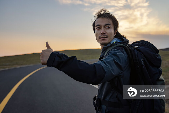 徒步旅行的男子做搭便车手势