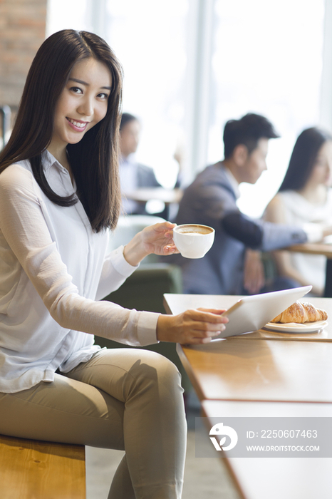 年轻女子在咖啡厅使用平板电脑