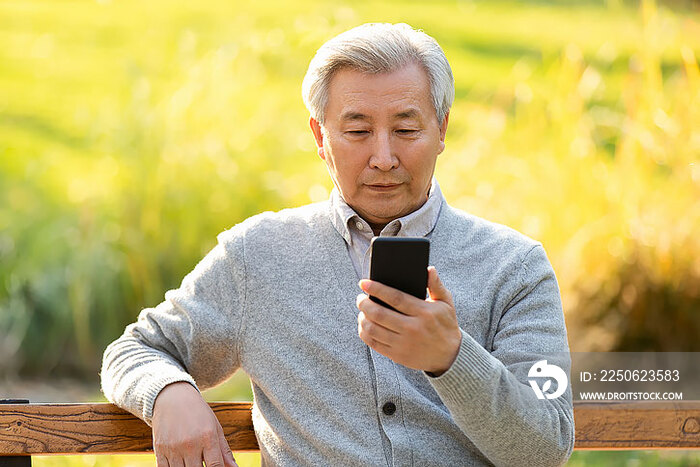 老年男子在公园使用手机