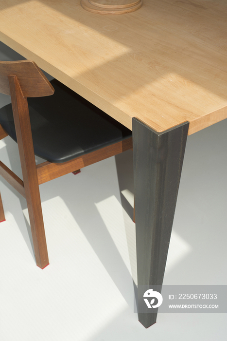 Close-up shot of a cropped wooden dining table and chair at home