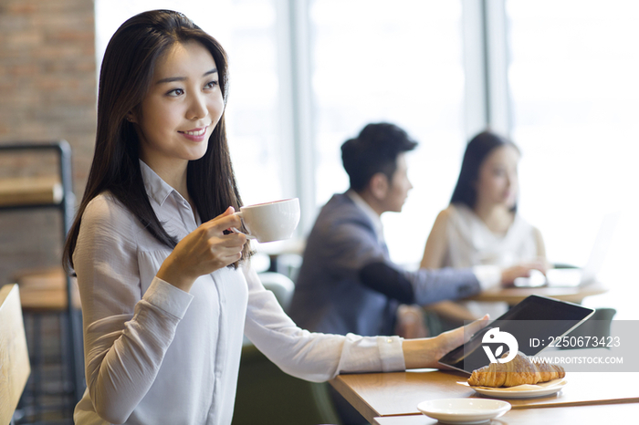 年轻女子在咖啡厅使用平板电脑