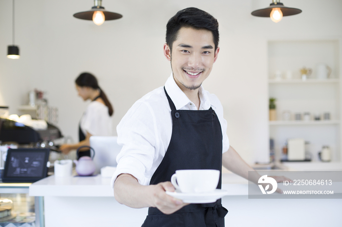 咖啡店店长端着一杯咖啡