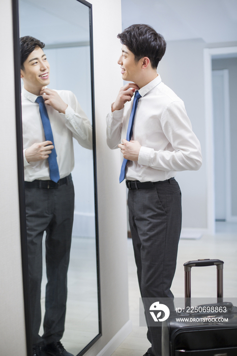 年轻男子在镜子前检查着装