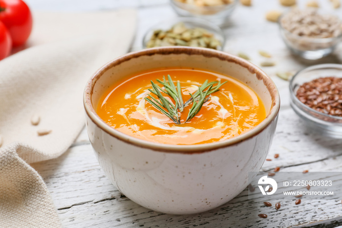 Tasty pumpkin cream soup in bowl on table