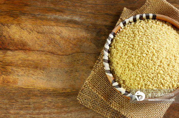 Primo piano del cous cous in una ciotola sulla tavola di legno.