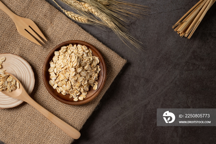 Oat flakes in wooden bowl top view. Concept healthy eating, dieting and vegetarian food.