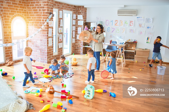 漂亮的老师和一群蹒跚学步的孩子在幼儿园玩很多玩具