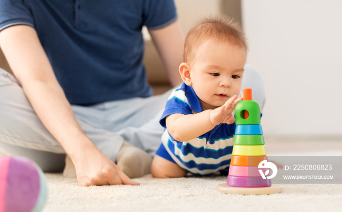 家庭、父亲身份和童年概念——家里有父亲和玩具金字塔的快乐男婴