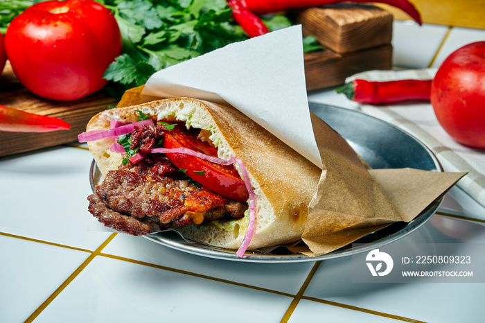 Tasty street food - pita with tomato, onion and sauce, beef burger on a white background. Greek cuis