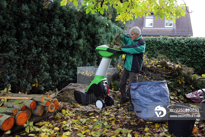 Herbst-Arbeitsplatz im Garten mit Häcksler und Kompost