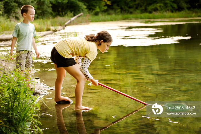 Brother and sister cleaning lake